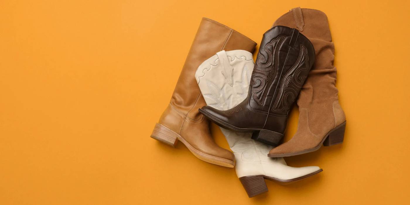 Four Western and tall women's boots stacked on top of one another.